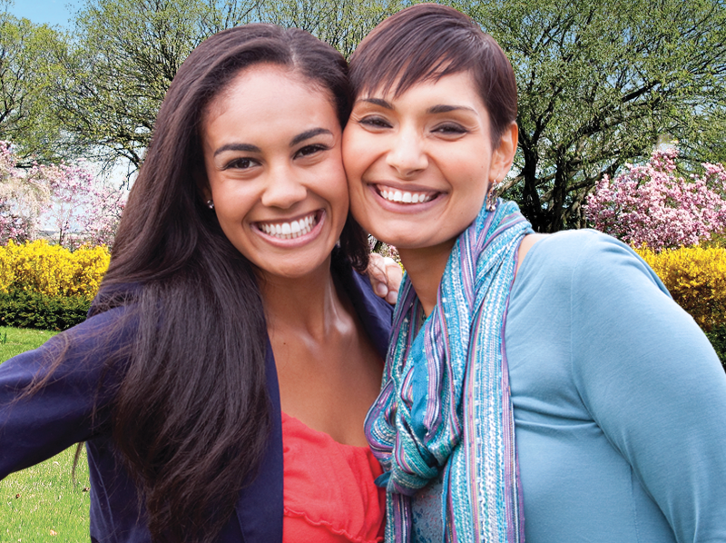 Two lady friends smiling outside.