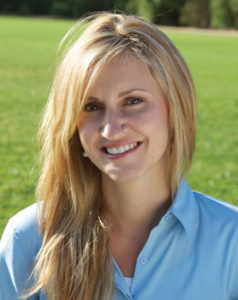 A woman smiling outside.