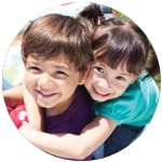 A young boy and girl hugging and smiling.